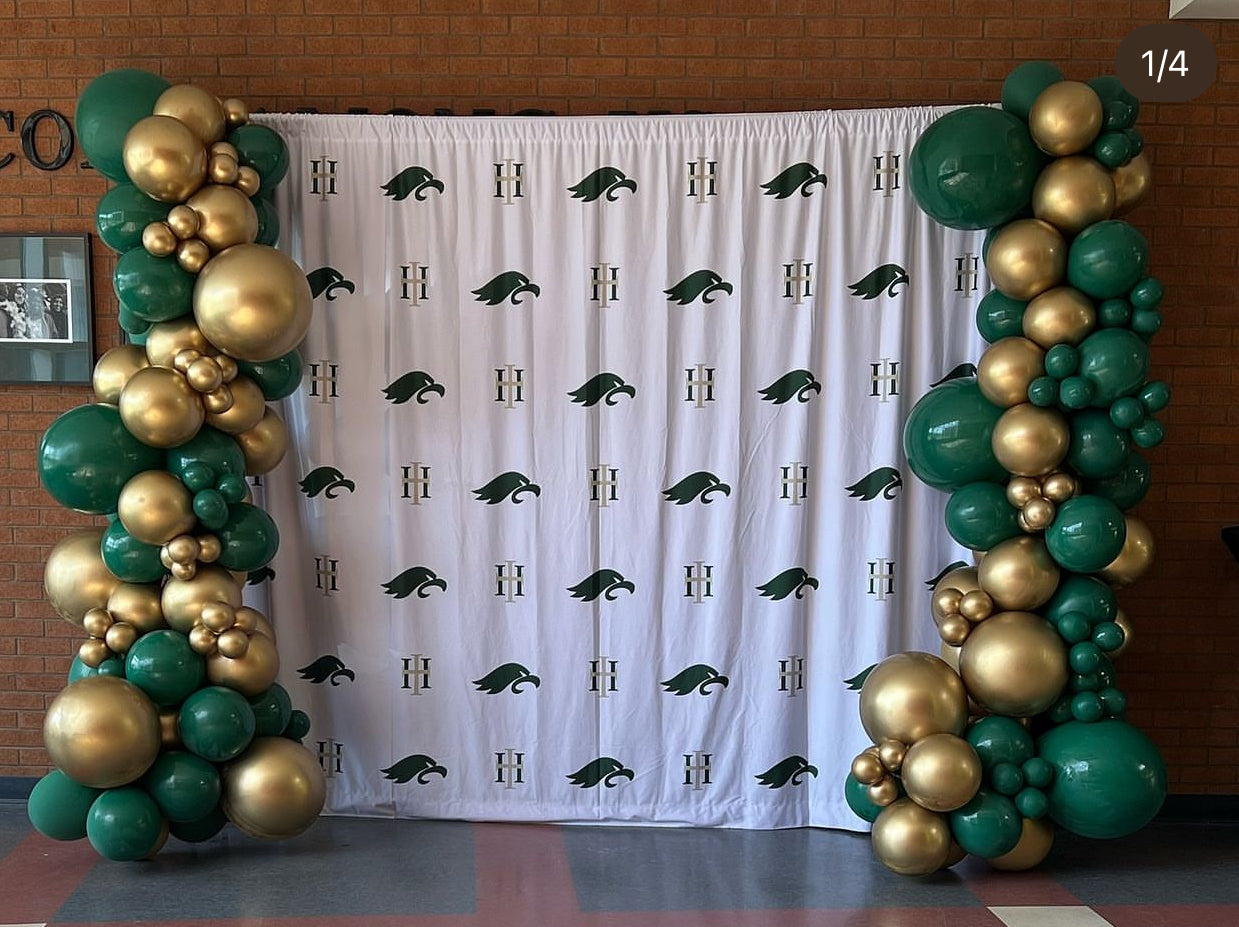two balloon garlands framing in a step and repeat backdrop for holy trinity catholic hight school