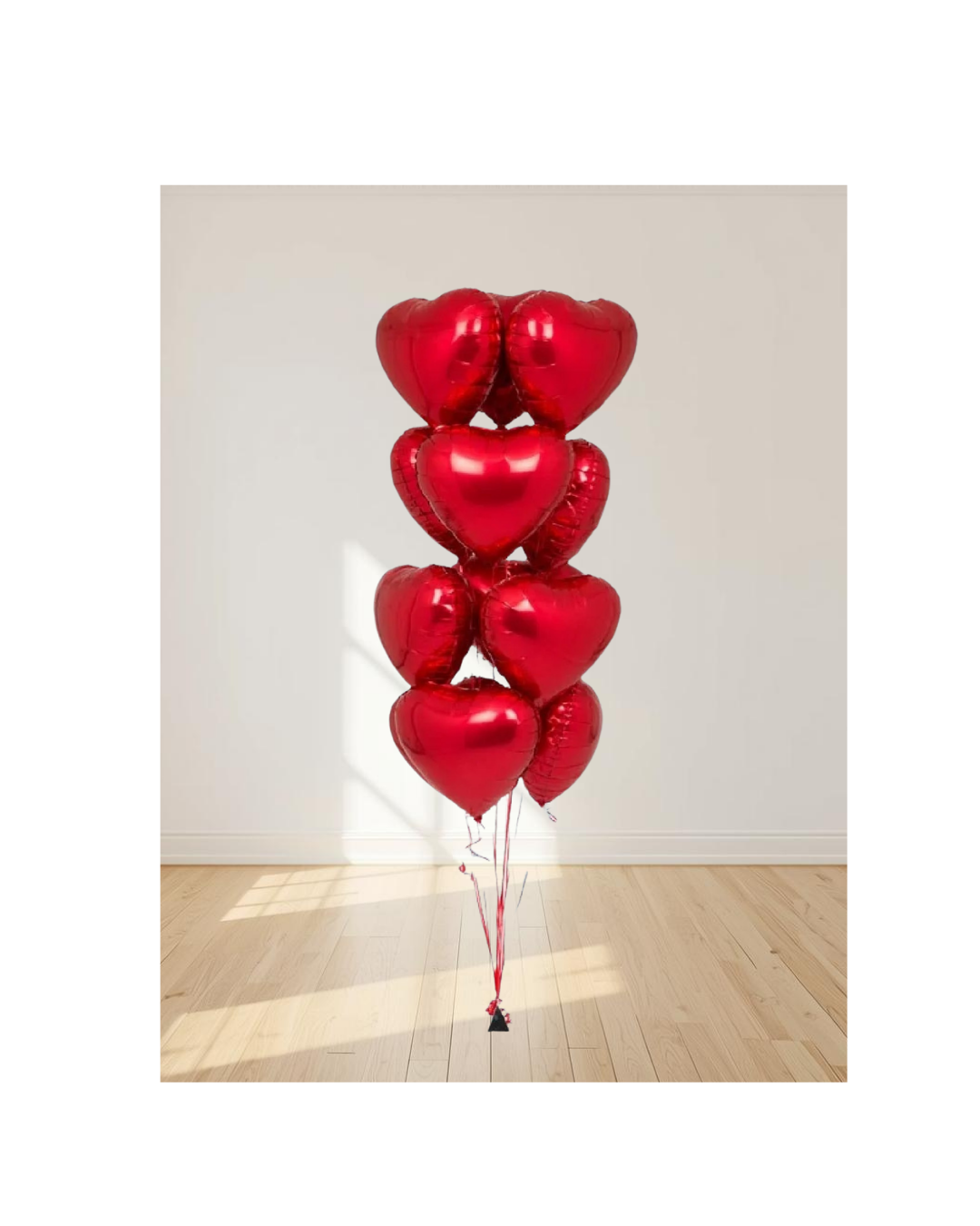 Bunch of red heart-shaped balloons on a wooden floor with a light gray wall background